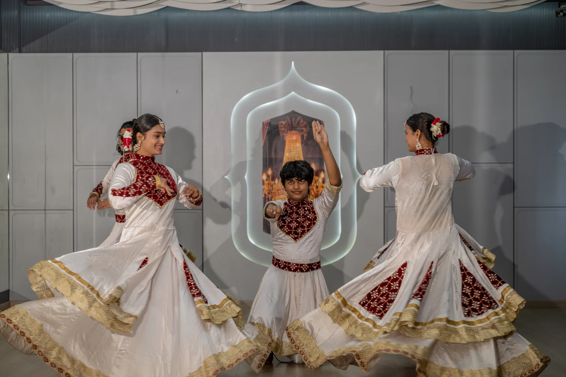 Kathak dancers turning in white, red and gold costumes