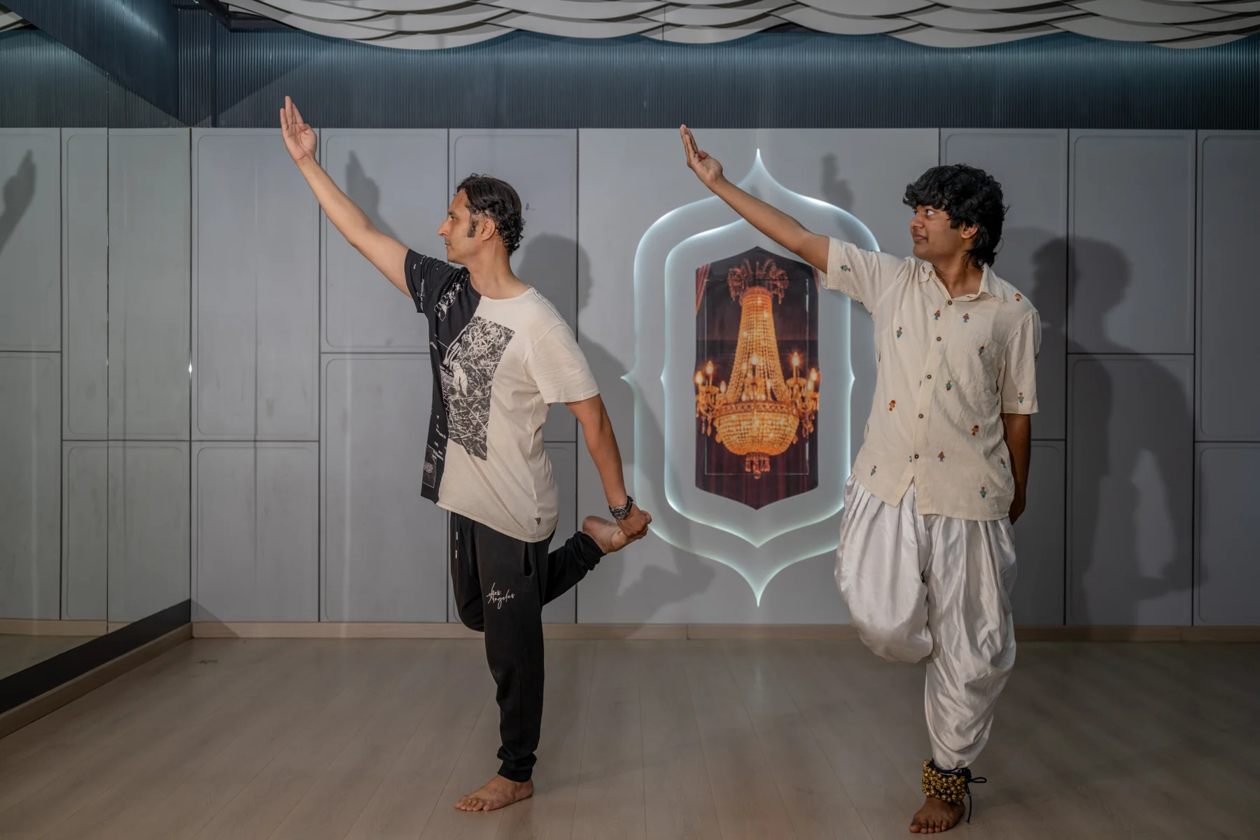 Practising a one-legged Kathak pose alongside an instructor