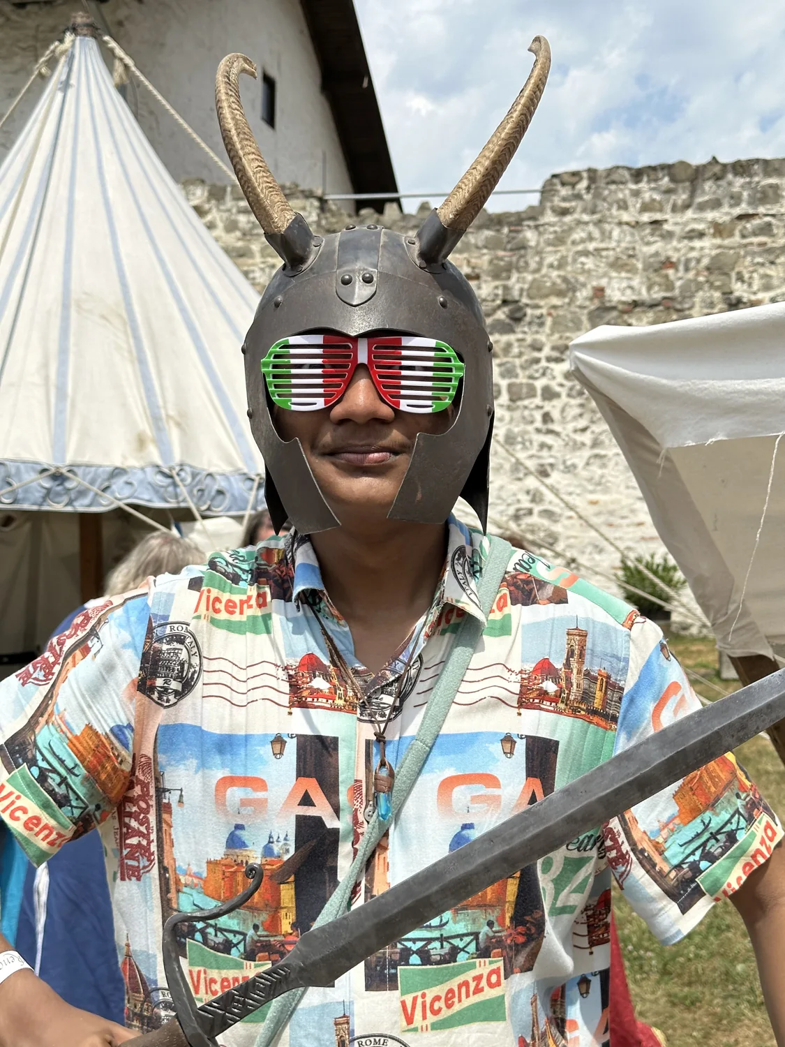 Wearing a horned helmet and colourful sunglasses