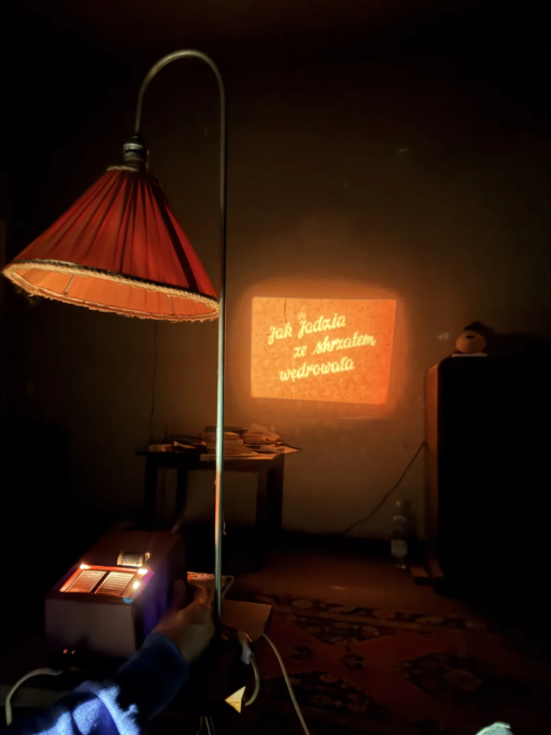 A warmly lit room with a shaded lamp