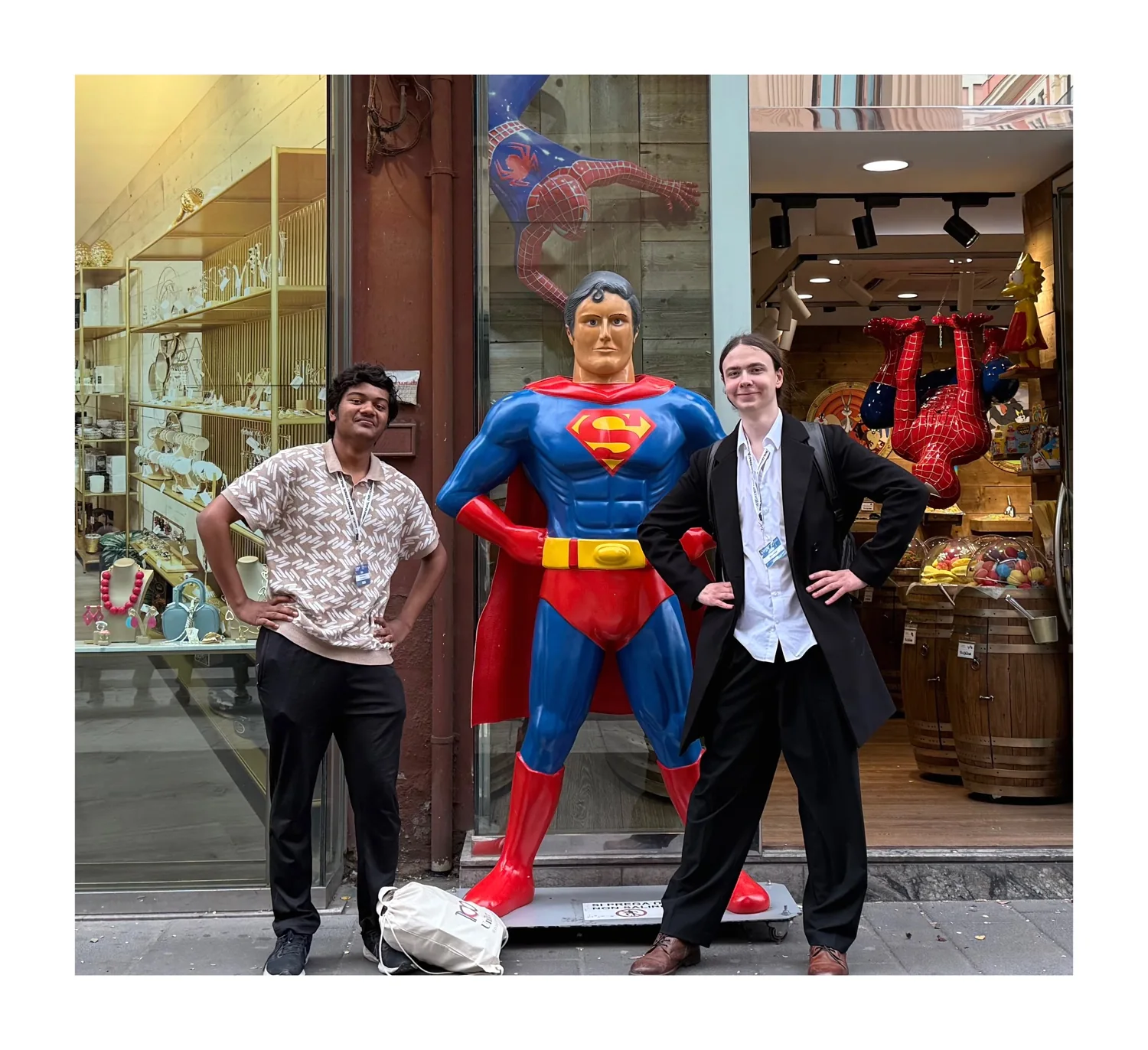 Posing with a friend beside a Superman statue